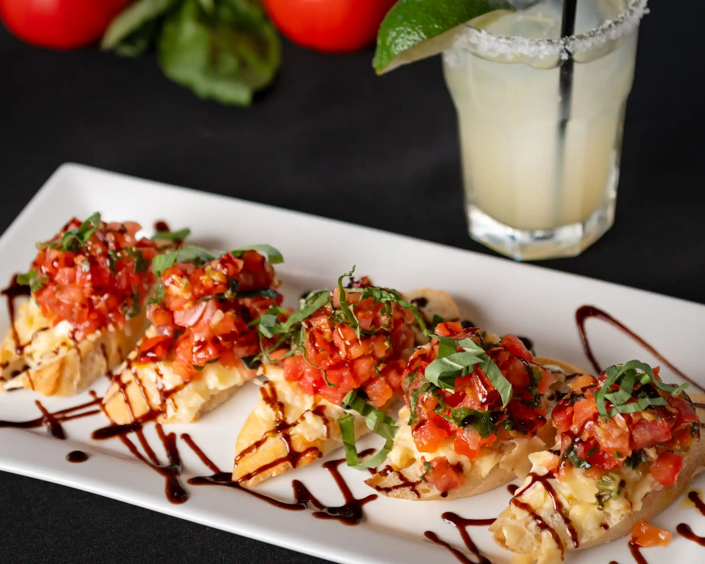 Bruschetta topped with tomatoes, basil, cheese, and balsamic glaze.